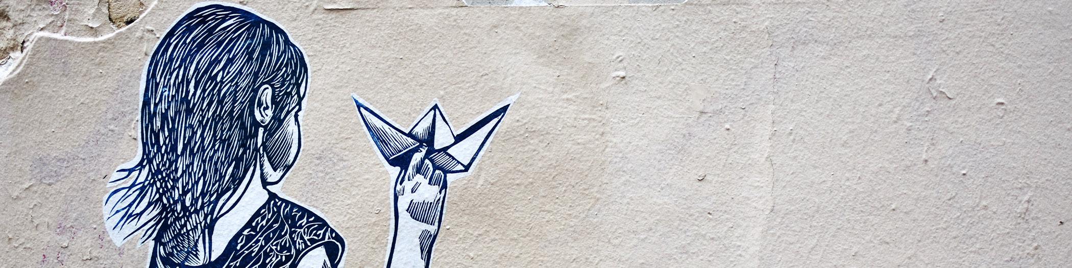 Graffiti of girl with a paper boat